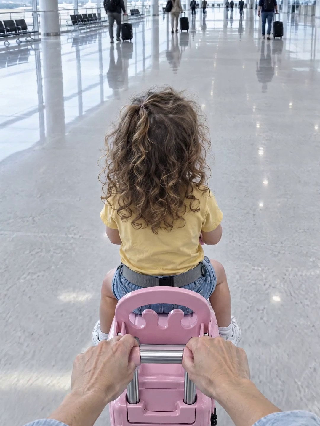 Parent's view pulling a child on a pink Rolli